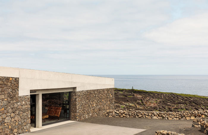 Adega Pico Winery and Hotel entrance wall blending in to stone surroundingsjpg