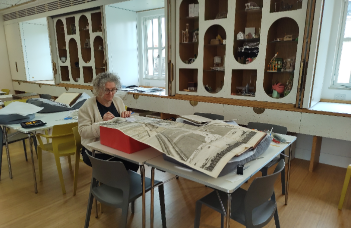 female at table with large format conservation drawingspng