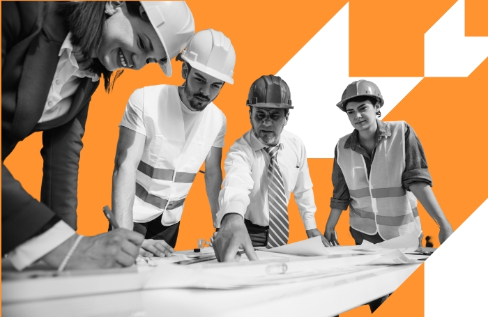 A group of architects wearing hard hats looking at designs with orange background GC LARGEjpg