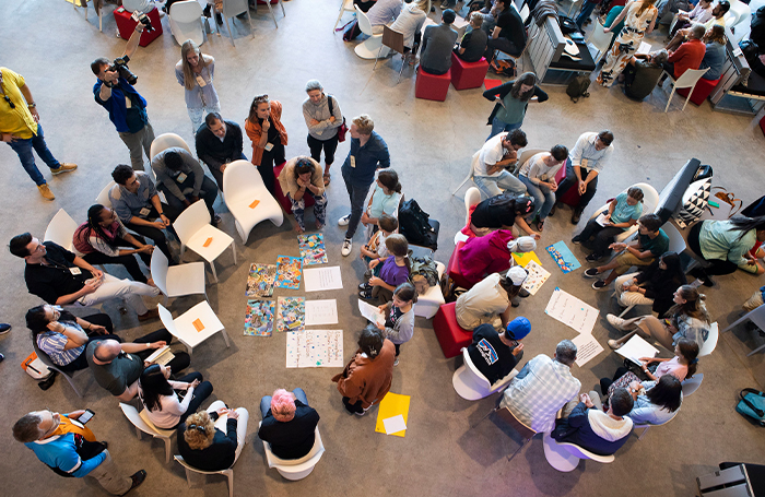 Aerial view of adults and children sitting in circles doing an activity 700jpg