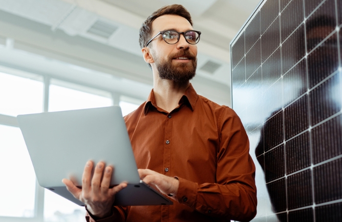 Architect with beard holding a laptop and looking into the distance GC LARGEjpg