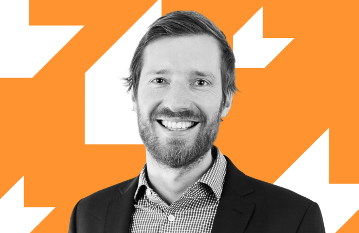Man smiling to camera with orange background LARGEpng