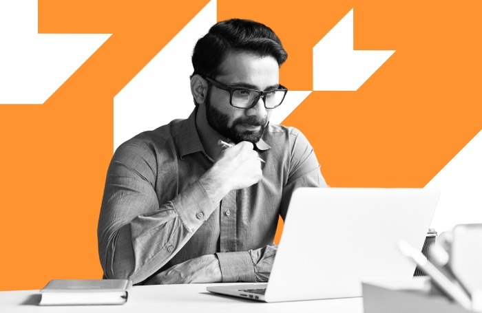 Man working in an office on a laptop with orange background LARGEjpg