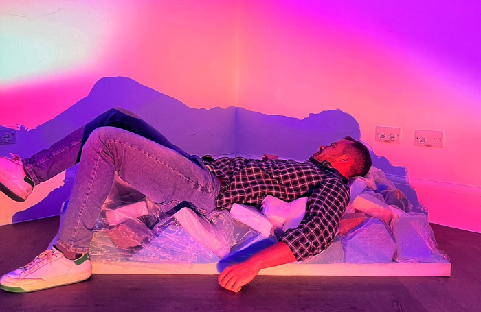 Neurodiversity Architecture Network launch partypng Man lying on miscellaneous foam blocks bathed in purple, pink, and orange lights