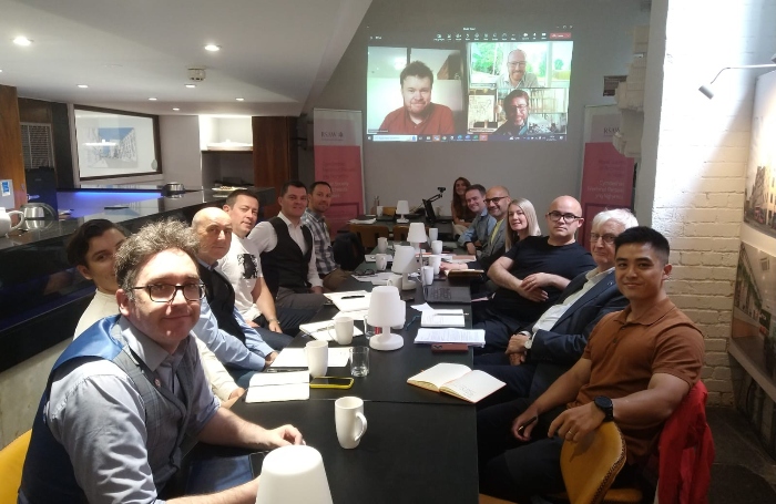 RSAW Council image 1jpg RSAW Council seated at a table with a projection of an online meeting at the back