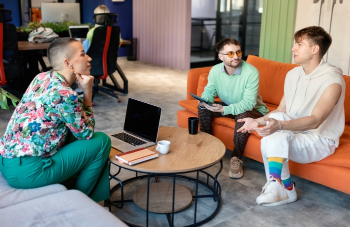 Two men sitting chatting to a woman in an office meeting space GC LARGEjpg