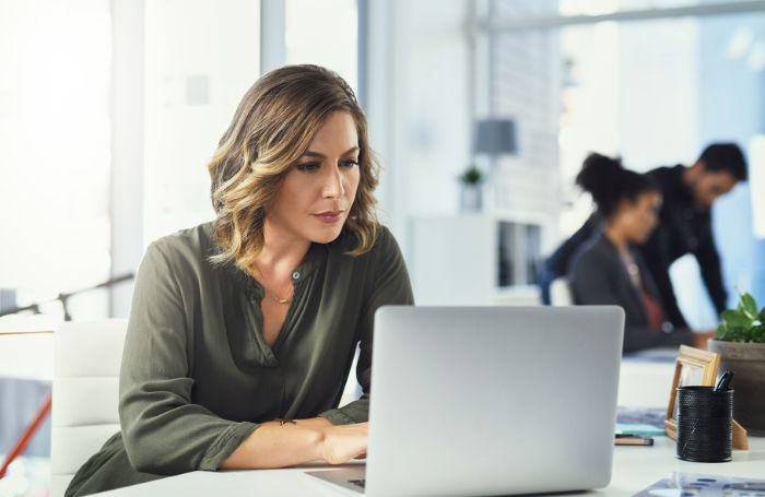 Woman sat a desk working on a laptop GC LARGEjpg