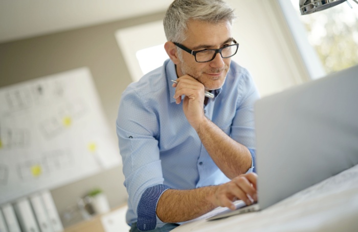 man smiling looking at laptop 700jpeg