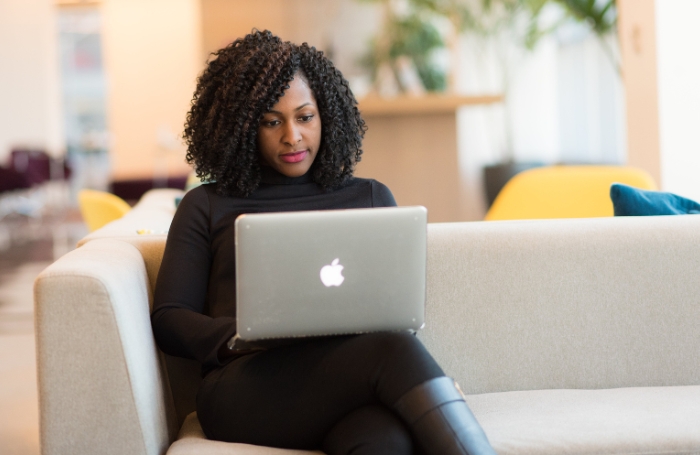 woman sitting on a sofa working on a laptop LARGEjpg