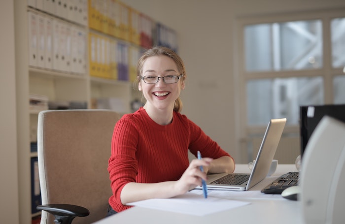 Female architect smiles as she works in an officejpg