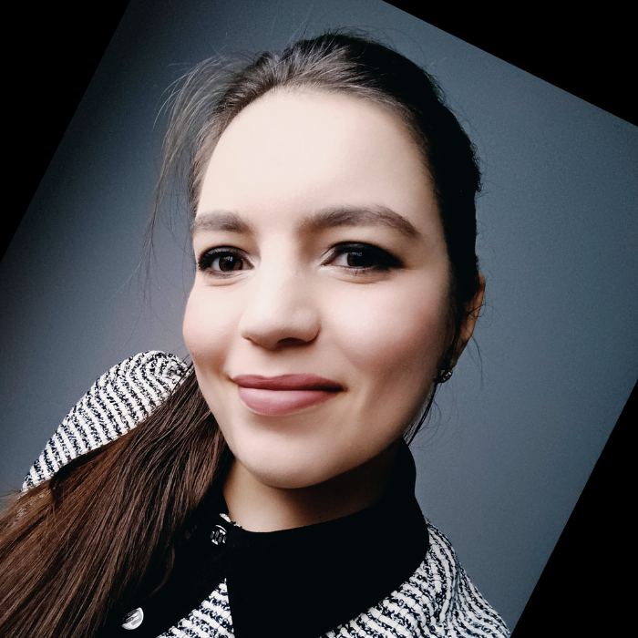Luisa Pires founder of the Neurodiversity Architecture Networpng Woman with brown hair tied into side ponytail and looking directly into camera at an angle.