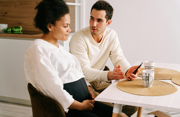 Pregnant woman sitting at table talking to colleguejpg