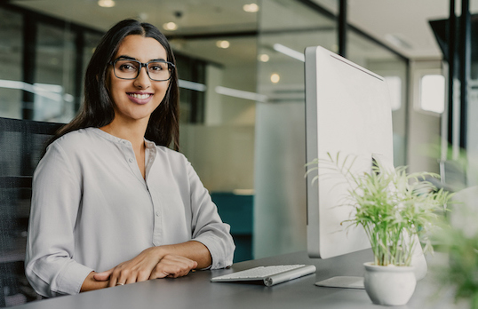 South Asian woman sitting at a desk in an office SMALLjpg