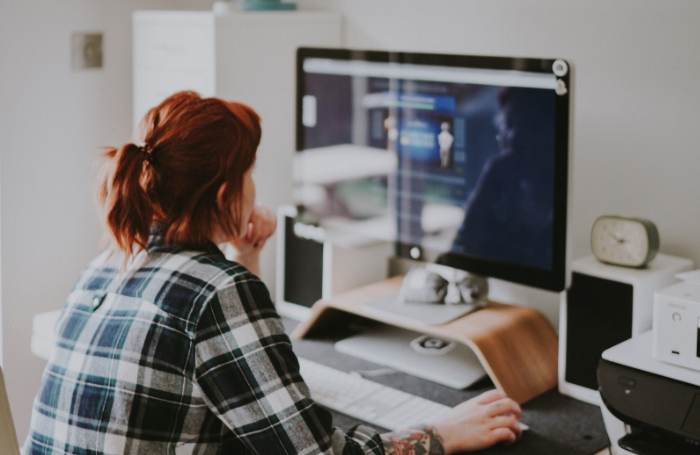 Woman working at home sitting in fron of a computer screenjpg