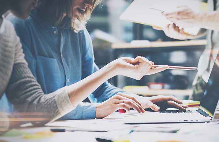 two women using a laptop on a desk Addressing Gender Inequity in the Built Environment EDItoolkit 1j Two people working at laptops, one is pointing at a screen