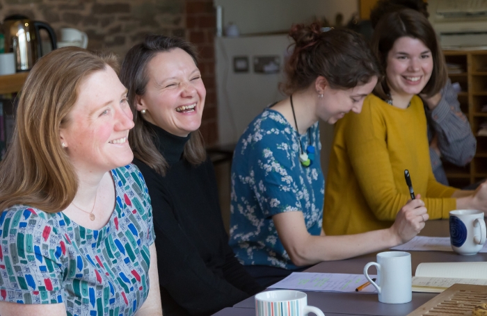 A group of female architects sitting around a table and laughing and discussing an issue GC LARGEjpg