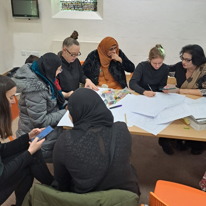 A group of people from different cultures discussing an architecture project around a tablejpg