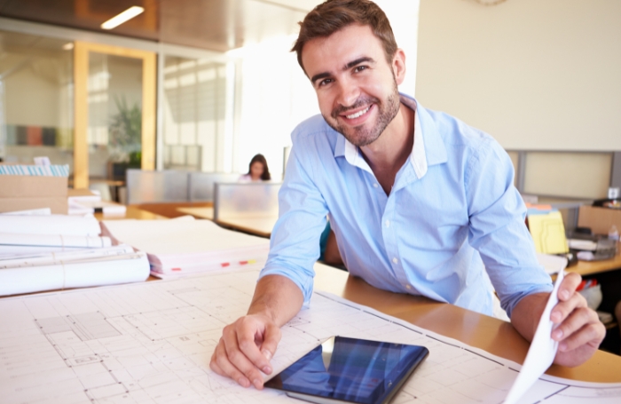 Architects smiling and looking to the camera in an officejpg