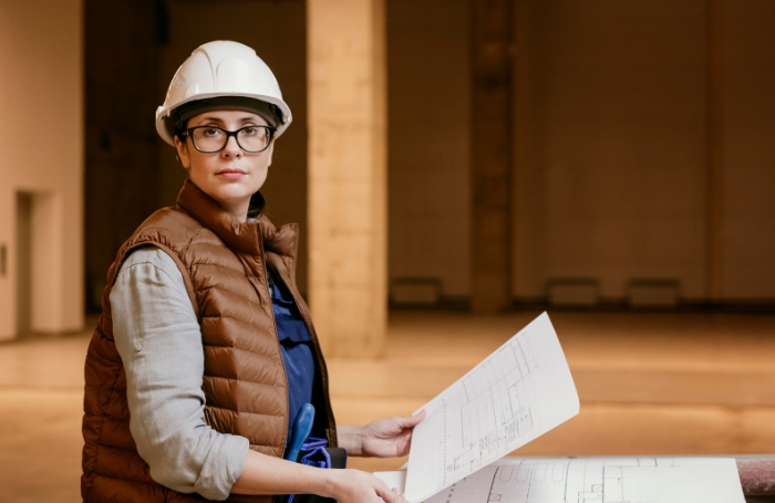 Female architect on site looking stright to camera wearing a hard hatjpg