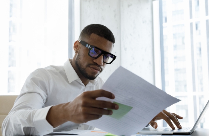 Man sitting at a desk reading through papersjpg