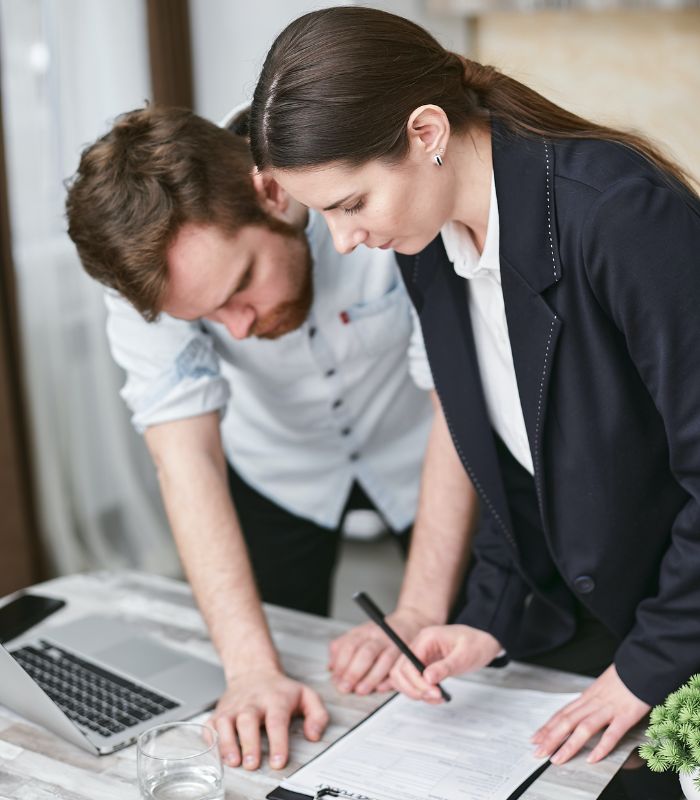 Two people in an office looking at contractsjpg