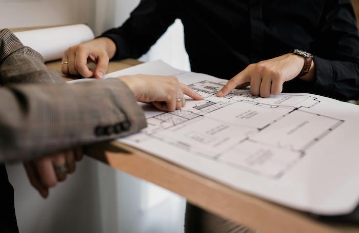 Two people looking and discussing house blueprintsjpg