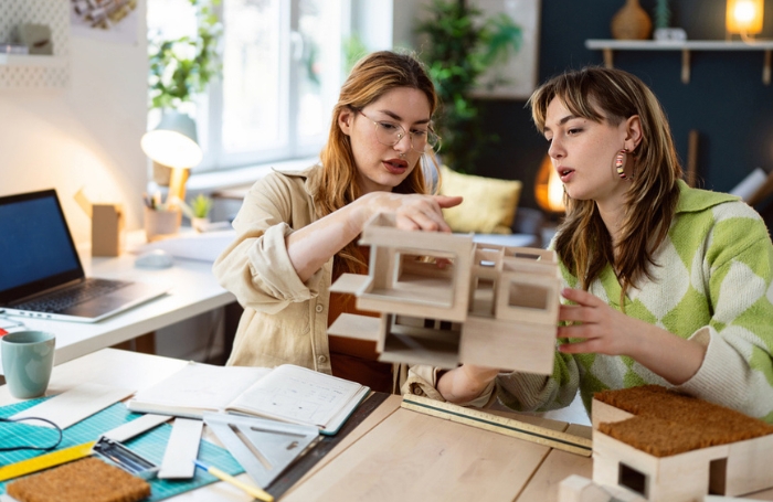 Two young women experimenting with architure model in an officejpg
