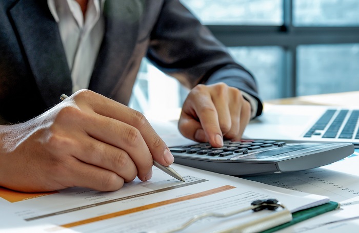 man hands working countng taxes on calculator 700x455jpg