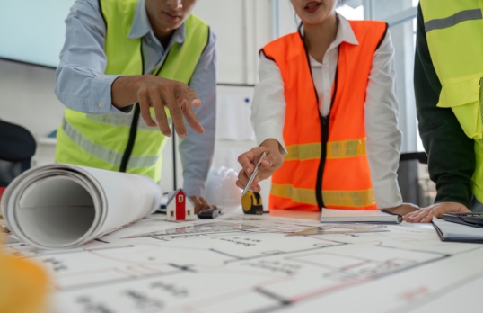 Architects standing around structural drawings