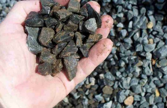 Hand holding multiple rocks and pebbles