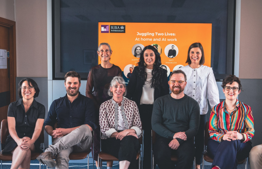 Speakers and Women in Architecture representatives at 66 Portland Place. They are in two rows, the front are seated. Behind them is a screen.