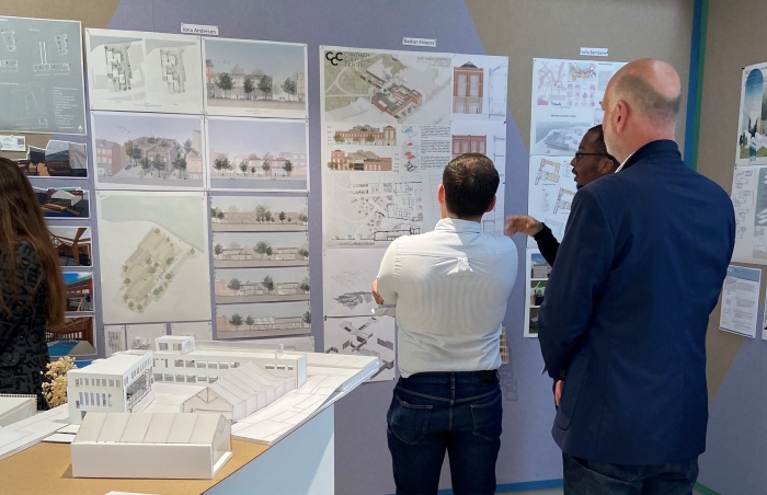 Judges looking at presentation boards on the wall.