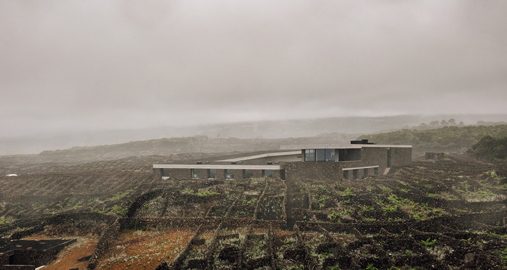 Adega Pico Winery and Hotel exterior surrounded by vineywards and clouds